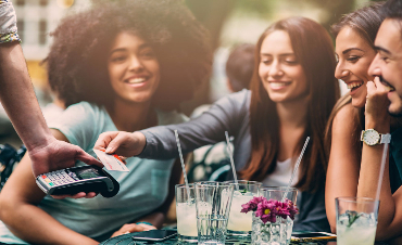 A group of friends paying for lunch with a credit card