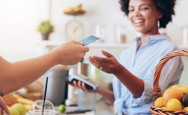 A person handing over a debit/credit card over to a cashier