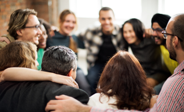 A diverse group of people in a friendly huddle